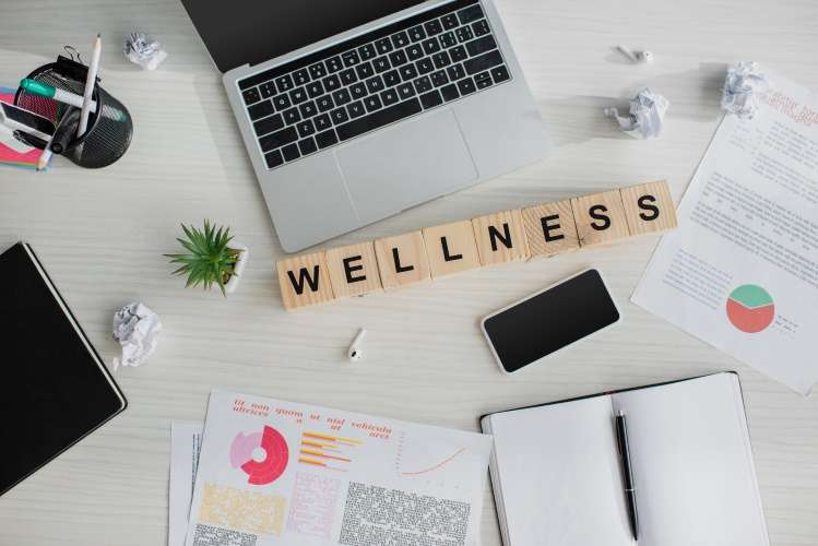 Laptop with building blocks spelling out wellness